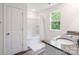 Bright bathroom featuring a granite countertop, white vanity, and a shower-tub combo, creating a fresh and inviting space at 7308 Rothmore St, Charlotte, NC 28215