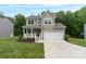 Charming two-story home features a covered porch, attached two car garage, and well-manicured lawn at 7308 Rothmore St, Charlotte, NC 28215