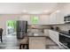 Bright kitchen featuring stainless appliances, granite counters, an island, and white cabinets at 7308 Rothmore St, Charlotte, NC 28215