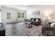 Inviting living room features gray couches, modern decor, a white door and stylish wood-look flooring at 7308 Rothmore St, Charlotte, NC 28215