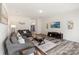 Bright living room features gray couches, modern decor, a large TV, and stylish wood-look flooring at 7308 Rothmore St, Charlotte, NC 28215