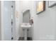 Charming powder room featuring a pedestal sink, framed mirror, and modern decor at 7308 Rothmore St, Charlotte, NC 28215