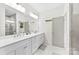 An en-suite bathroom boasts double sinks, ample counter space, and stylish modern fixtures for a spa-like experience at 7683 Sarah Dr, Denver, NC 28037