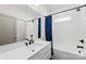 Modern bathroom with white subway tile, dark fixtures, and a shower-tub combination with a blue shower curtain at 7683 Sarah Dr, Denver, NC 28037