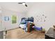 Cozy bedroom with a bunk bed, wood floors, and a bright window overlooking the yard at 7683 Sarah Dr, Denver, NC 28037