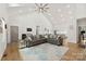 Bright living room with vaulted ceiling, wood floors, and a large sectional sofa on a decorative rug at 7683 Sarah Dr, Denver, NC 28037