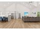 Open-concept living space with modern kitchen, comfortable gray sofa, high ceilings, and hardwood floors, ideal for entertaining at 7683 Sarah Dr, Denver, NC 28037