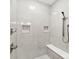 Modern shower featuring gray tiling with a shower bench and integrated shelving at 7683 Sarah Dr, Denver, NC 28037