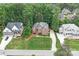 An aerial view shows a well-manicured lawn, driveway, and mature trees surrounding a brick house at 7738 Burning Ridge Dr, Stanley, NC 28164