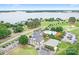 Stunning aerial view showcasing a lakefront community with a clubhouse, pool, golf course, and tennis courts at 7738 Burning Ridge Dr, Stanley, NC 28164
