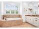 Bright bathroom featuring a soaking tub, vanity, and large window with natural light at 7738 Burning Ridge Dr, Stanley, NC 28164