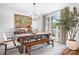 Elegant dining room featuring a large window, modern chandelier, and dining table with bench seating at 7738 Burning Ridge Dr, Stanley, NC 28164
