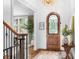 Inviting foyer with hardwood floors, an arched front door with iron detailing, and a decorative chandelier at 7738 Burning Ridge Dr, Stanley, NC 28164