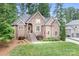 A two story brick home has a meticulously maintained lawn and professional landscaping for curb appeal at 7738 Burning Ridge Dr, Stanley, NC 28164