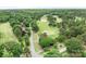 Scenic aerial view of the meticulously maintained golf course featuring lush green fairways, sand traps, and a small pond at 7738 Burning Ridge Dr, Stanley, NC 28164