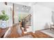 Open-concept living room boasts hardwood floors, a stone fireplace, and abundant natural light from large windows at 7738 Burning Ridge Dr, Stanley, NC 28164