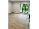 Light-filled bedroom with wood-look flooring and a large window overlooking greenery at 8029 Cedar Glen Dr, Charlotte, NC 28212
