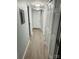 Hallway with wood-look flooring and crisp white trim; multiple doors for storage at 8029 Cedar Glen Dr, Charlotte, NC 28212