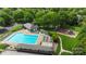 Aerial view of the community pool with ample seating, a playground, and lush landscaping at 8605 Tamarron Dr, Charlotte, NC 28277