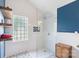 Bright bathroom featuring a walk-in shower with patterned floor tile and a blue accent wall at 8605 Tamarron Dr, Charlotte, NC 28277