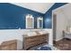 Bathroom featuring double sink vanity, custom mirrors, decorative tile flooring, and bold navy accent wall at 8605 Tamarron Dr, Charlotte, NC 28277