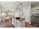 Modern kitchen island with black granite countertop, stainless steel refrigerator, and open view to living area at 8605 Tamarron Dr, Charlotte, NC 28277