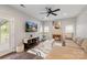 Cozy living room with fireplace, ceiling fan, mounted TV, and large windows for natural light at 8605 Tamarron Dr, Charlotte, NC 28277
