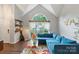 Bright living room with vaulted ceiling, oversized window, hardwood floors, and a comfortable blue sectional sofa at 8605 Tamarron Dr, Charlotte, NC 28277