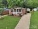 Charming brick home with a well-maintained front yard, landscaping, and a long driveway leading to the house at 906 Eastwood Dr, Rock Hill, SC 29730