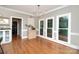 Bright dining room with beautiful hardwood floors and a cabinet with an artistic floral arrangement at 915 Waterview Ln, Monroe, NC 28110