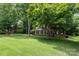 A beautiful brick home with a long driveway, surrounded by mature trees and lush green lawn at 915 Waterview Ln, Monroe, NC 28110