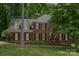 Charming two-story brick home with black shutters and a well-manicured lawn nestled among mature trees at 915 Waterview Ln, Monroe, NC 28110