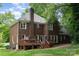 Beautiful brick home with a large backyard, wooden deck, mature trees, and well-maintained landscaping at 915 Waterview Ln, Monroe, NC 28110