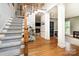 Bright foyer with hardwood floors, staircase, white trim, and views into the living spaces at 915 Waterview Ln, Monroe, NC 28110
