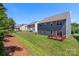A tiered wood deck overlooks this spacious lawn, nestled against a tree-lined horizon at 9230 Loch Glen Way, Charlotte, NC 28278