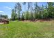 Expansive backyard featuring lush lawn, tall trees, and a wooden deck perfect for outdoor gatherings at 9230 Loch Glen Way, Charlotte, NC 28278