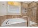 Cozy bathroom features a corner soaking tub with tiled backsplash and glass enclosed shower at 9230 Loch Glen Way, Charlotte, NC 28278