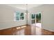 Bright dining area with hardwood floors, modern light fixture, and sliding glass doors to deck at 9230 Loch Glen Way, Charlotte, NC 28278