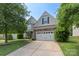Charming home with a two-car garage, stone accents, and a well-maintained lawn at 9230 Loch Glen Way, Charlotte, NC 28278