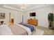 This virtually staged main bedroom features a chandelier, TV, walk-in closet and attached bathroom at 9230 Loch Glen Way, Charlotte, NC 28278
