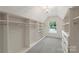 Bright walk-in closet boasts custom shelving and ample storage space with a window for natural light at 9230 Loch Glen Way, Charlotte, NC 28278