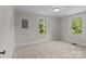 This carpeted bedroom features two windows that offer natural lighting at 94 Sumner Nw Ave, Concord, NC 28027