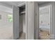 A walk-in closet with storage leading to a bathroom with a bathtub and a separate room with a window at 94 Sumner Nw Ave, Concord, NC 28027