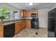 Sunny kitchen featuring wood cabinetry, black appliances, and a functional layout at 94 Sumner Nw Ave, Concord, NC 28027
