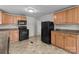 Practical kitchen with wood cabinets, black appliances, and durable tile flooring at 94 Sumner Nw Ave, Concord, NC 28027