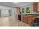 Efficient kitchen with wood cabinets, black appliances, tile floors, and washer/dryer hookups at 94 Sumner Nw Ave, Concord, NC 28027