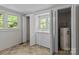 Bright laundry room featuring a washer, dryer, and water heater discreetly tucked behind folding closet doors at 94 Sumner Nw Ave, Concord, NC 28027