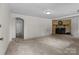 Spacious living room with neutral carpeting, a brick fireplace, and access to other rooms at 94 Sumner Nw Ave, Concord, NC 28027