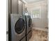 Functional laundry room with modern washer and dryer, complemented by ample cabinet storage space at 9433 Wallace Pond Dr, Huntersville, NC 28078