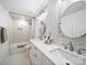 Bright bathroom features double vanity, large mirrors, and marble style tile in shower area at 9712 Worley Dr, Charlotte, NC 28215